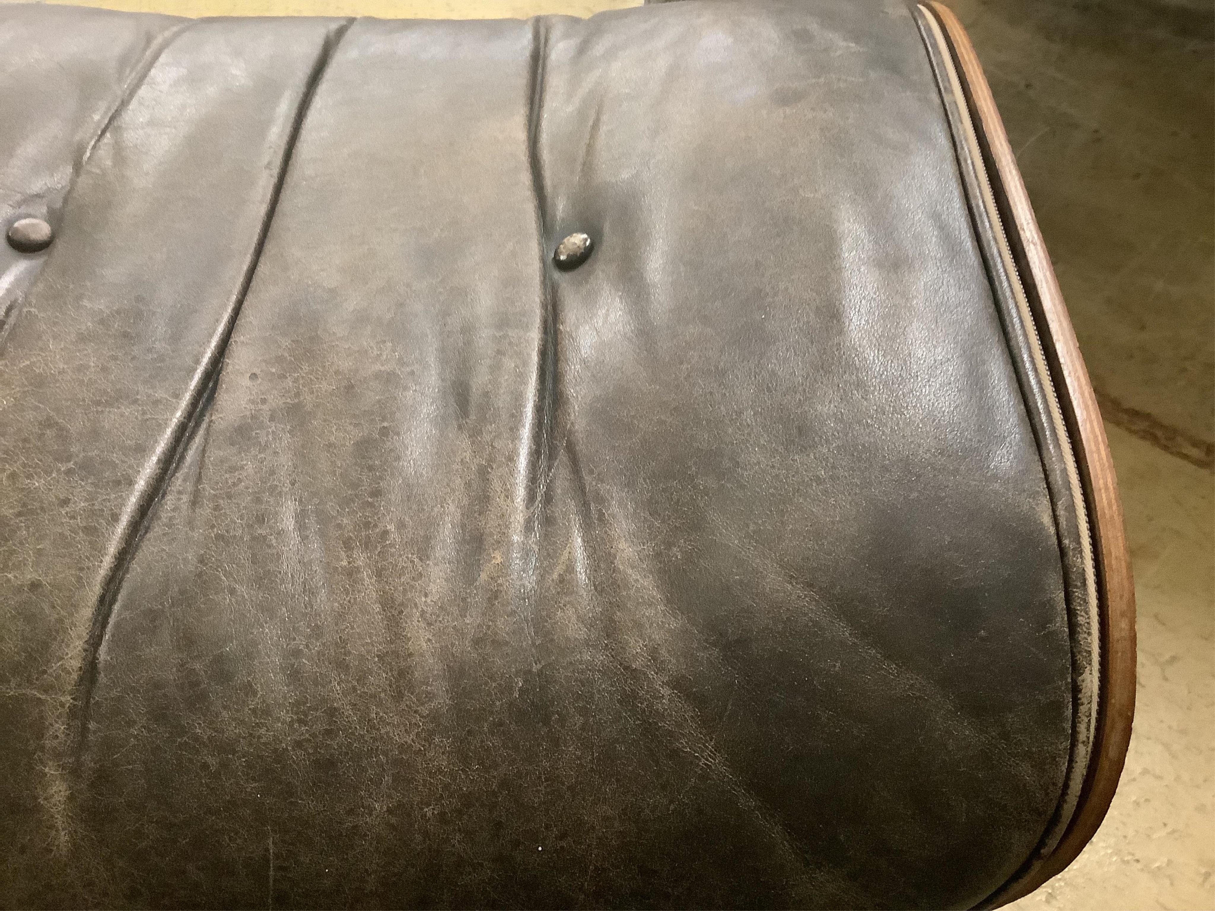 Charles and Ray Eames for Herman Miller Interform, an Indian rosewood and black leather lounge chair and ottoman, circa 1960, chair width 85cm, depth 68cm, height 81cm. Condition - poor to fair